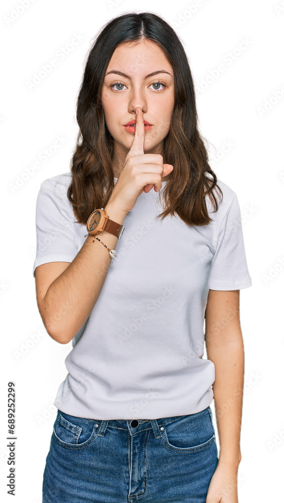 Young beautiful woman wearing casual white t shirt asking to be quiet with finger on lips. silence and secret concept. Young beautiful woman wearing casual white t shirt asking to be quiet with finger on lips. silence and secret concept.