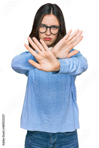 Young beautiful woman wearing casual clothes and glasses rejection expression crossing arms doing negative sign, angry face © Krakenimages.com