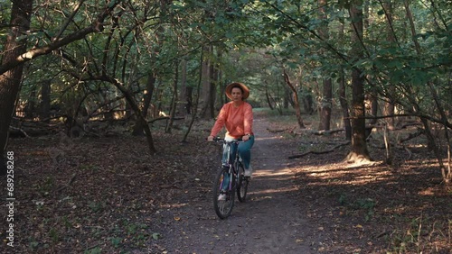 Wallpaper Mural Caucasian woman riding a scooter in the forest. The girl actively spends time in nature. High quality 4k footage Torontodigital.ca