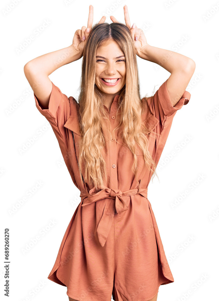 Beautiful caucasian woman with blonde hair wearing summer jumpsuit posing funny and crazy with fingers on head as bunny ears, smiling cheerful Beautiful caucasian woman with blonde hair wearing summer jumpsuit posing funny and crazy with fingers on head as bunny ears, smiling cheerful