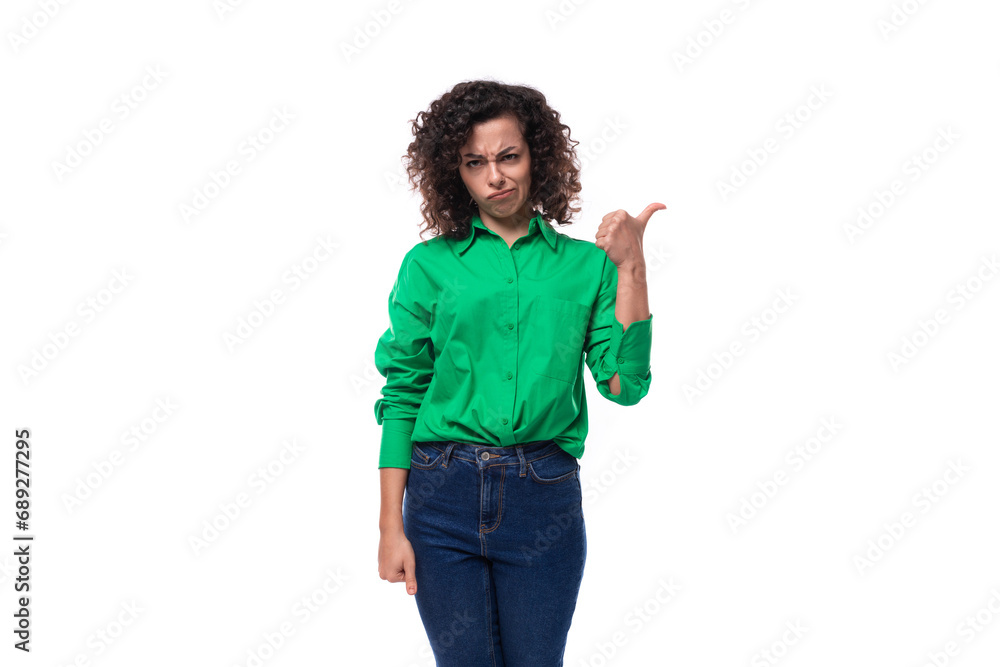 young caucasian lady with black curls is dressed in a green shirt on a white background young caucasian lady with black curls is dressed in a green shirt on a white background