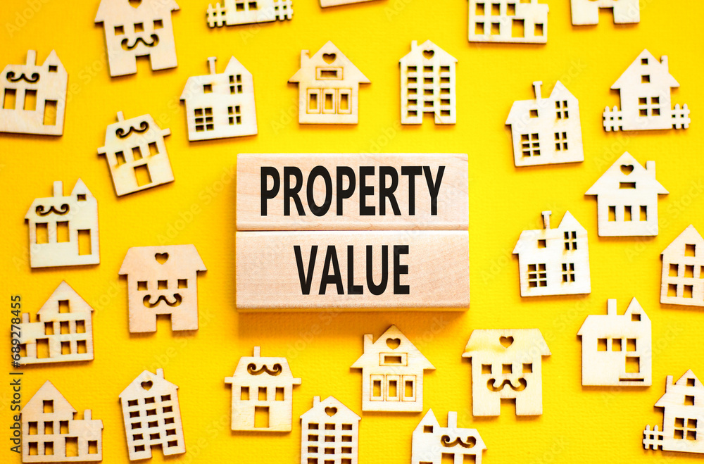 Property value symbol. Concept words Property value on beautiful wooden blocks. Beautiful yellow table yellow background. House model. Business property value concept. Copy space.