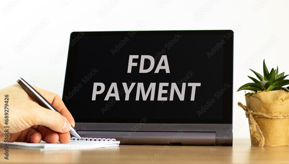 FDA Food and Drug Administration payment symbol. Concept words FDA payment on beautiful black tablet. Beautiful white background. Businessman hand. Business FDA payment concept. Copy space. FDA Food and Drug Administration payment symbol. Concept words FDA payment on beautiful black tablet. Beautiful white background. Businessman hand. Business FDA payment concept. Copy space.