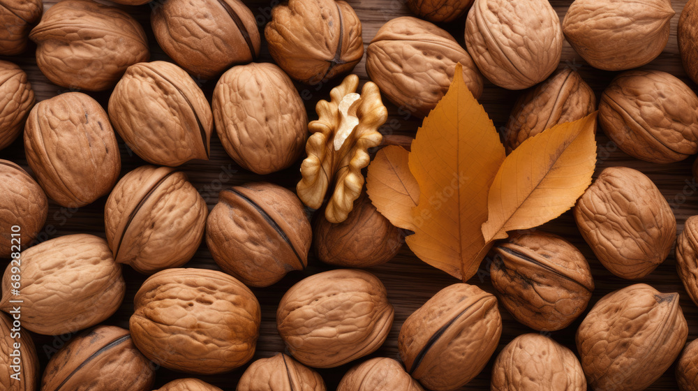 Walnuts with a leaf on a wooden table. Beautiful background of fresh walnuts for design. Top view. Walnuts with a leaf on a wooden table. Beautiful background of fresh walnuts for design. Top view.