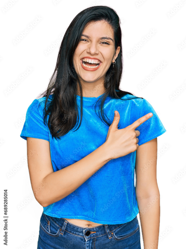 Young hispanic woman wearing casual clothes cheerful with a smile of face pointing with hand and finger up to the side with happy and natural expression on face Young hispanic woman wearing casual clothes cheerful with a smile of face pointing with hand and finger up to the side with happy and natural expression on face
