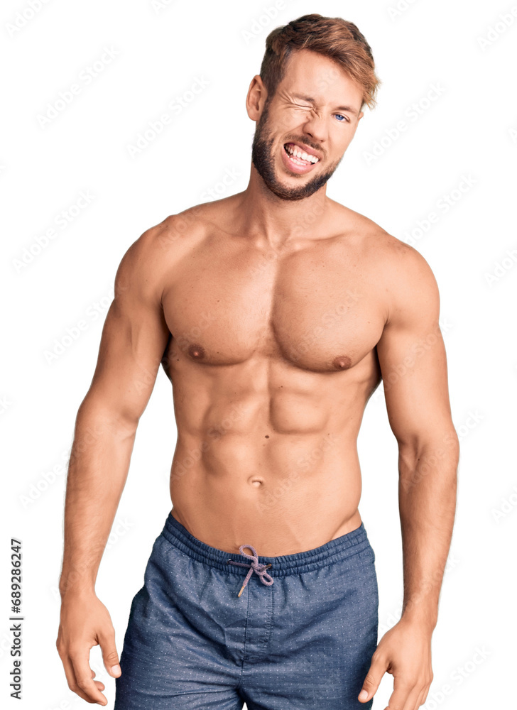 Young caucasian man standing shirtless winking looking at the camera with sexy expression, cheerful and happy face. Young caucasian man standing shirtless winking looking at the camera with sexy expression, cheerful and happy face.