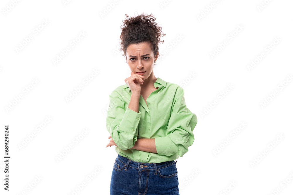 young smart slim european brunette curly woman with bun hairstyle dressed in green shirt and jeans young smart slim european brunette curly woman with bun hairstyle dressed in green shirt and jeans