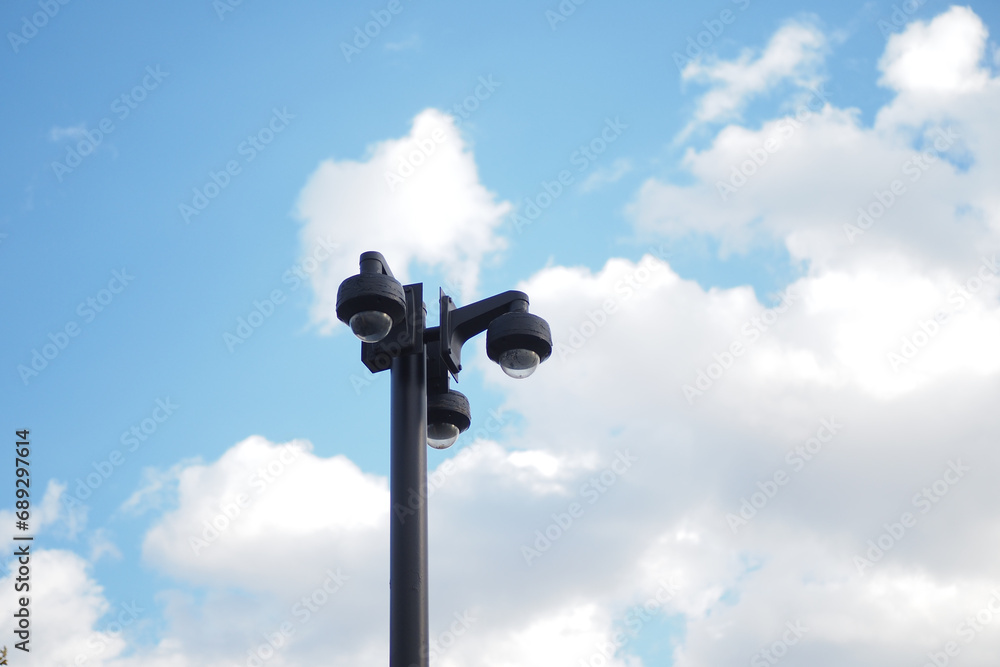 CCTV security camera operating outdoor against blue sky 