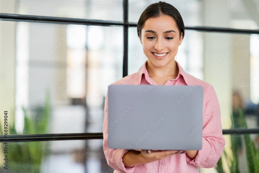 Happy young arab lady manager typing on laptop, enjoy project, planning startup Happy young arab lady manager typing on laptop, enjoy project, planning startup