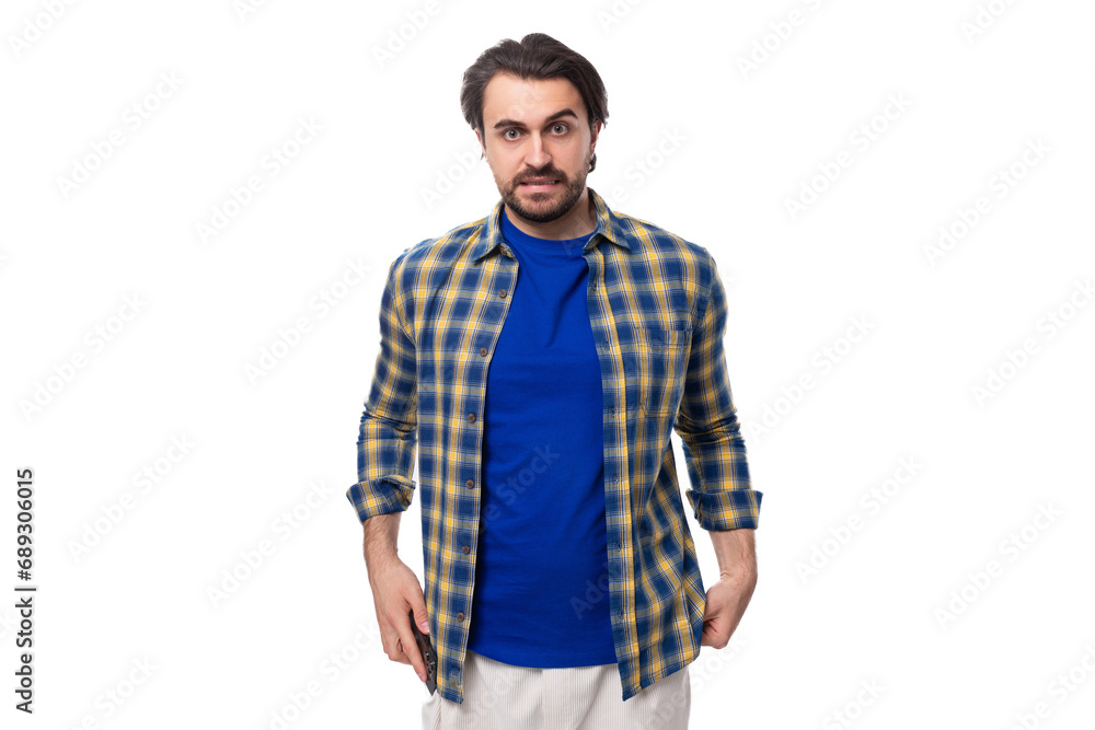 Fototapeta premium handsome young European brunette man with a well-groomed beard and mustache dressed casually in a summer look on a white background