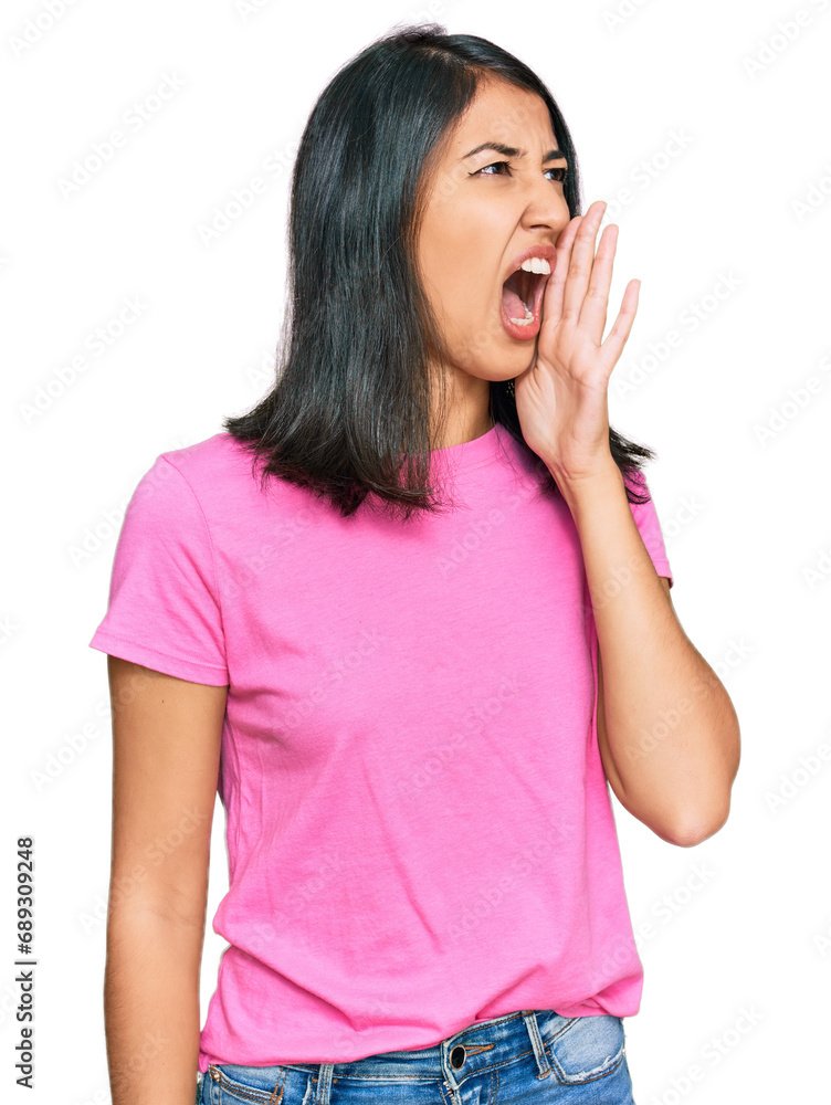 Beautiful asian young woman wearing casual pink t shirt shouting and screaming loud to side with hand on mouth. communication concept. Beautiful asian young woman wearing casual pink t shirt shouting and screaming loud to side with hand on mouth. communication concept.