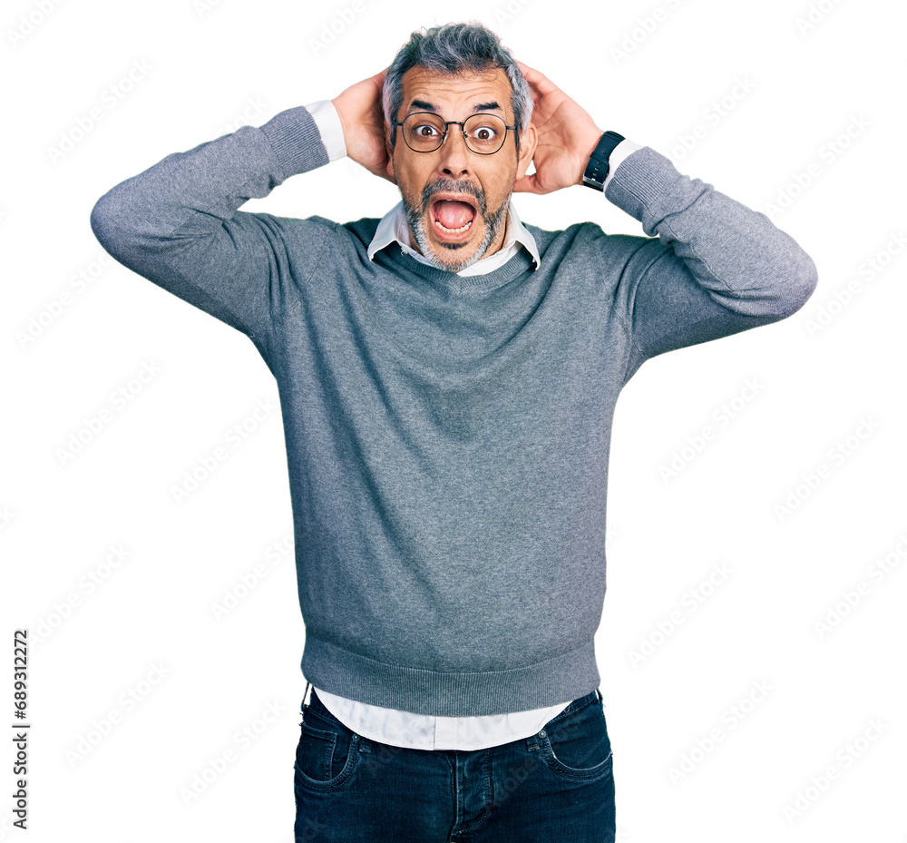 Middle age hispanic with grey hair wearing glasses crazy and scared with hands on head, afraid and surprised of shock with open mouth Middle age hispanic with grey hair wearing glasses crazy and scared with hands on head, afraid and surprised of shock with open mouth