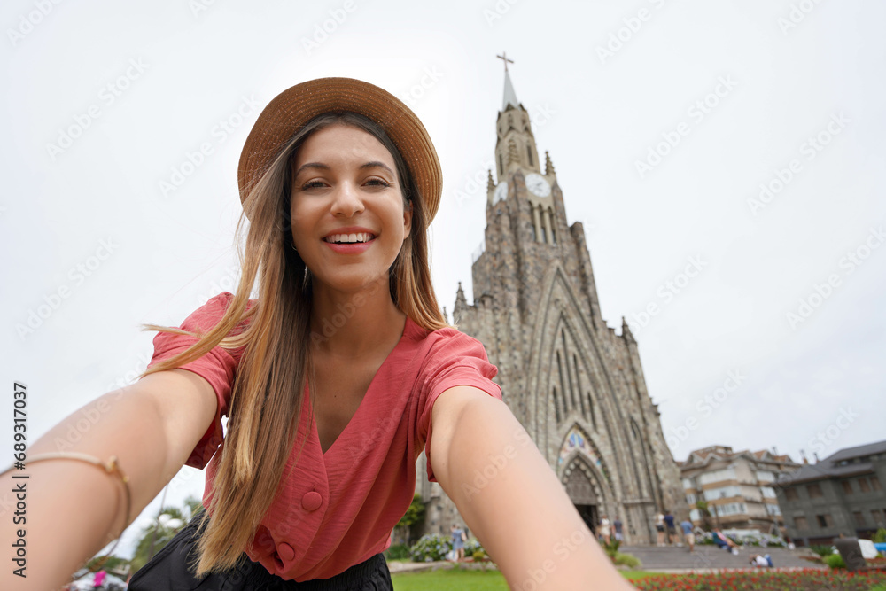 Selfie stylish girl in Canela, Brazil. Young woman taking self portrait with the church 