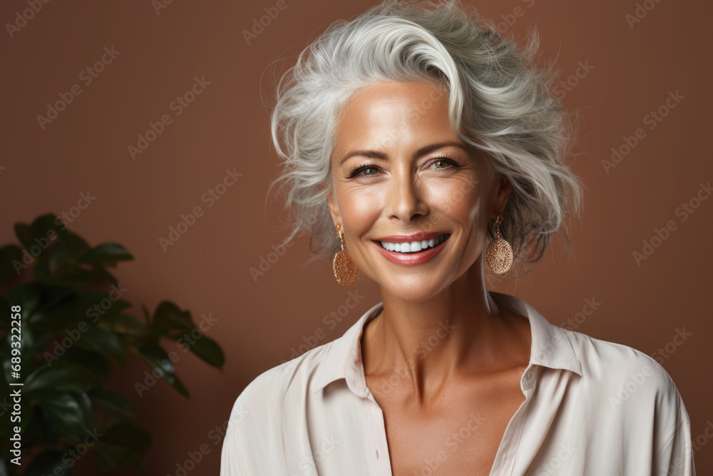Middle aged woman looking at camera. Happy mature woman portrait. Aged female model with smile on her face and good skin. Concept of self care and healthy lifestyle in old age Middle aged woman looking at camera. Happy mature woman portrait. Aged female model with smile on her face and good skin. Concept of self care and healthy lifestyle in old age