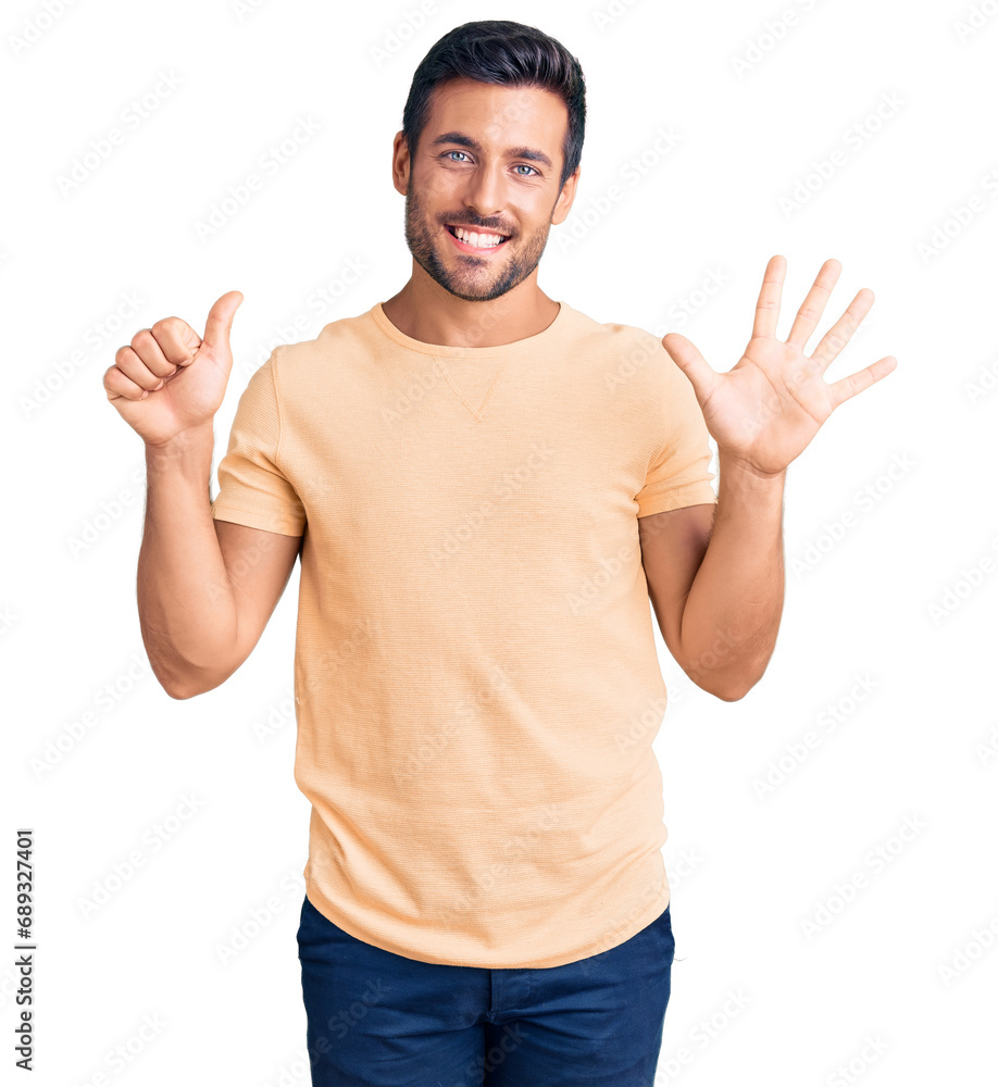 Naklejka premium Young hispanic man wearing casual clothes showing and pointing up with fingers number six while smiling confident and happy.