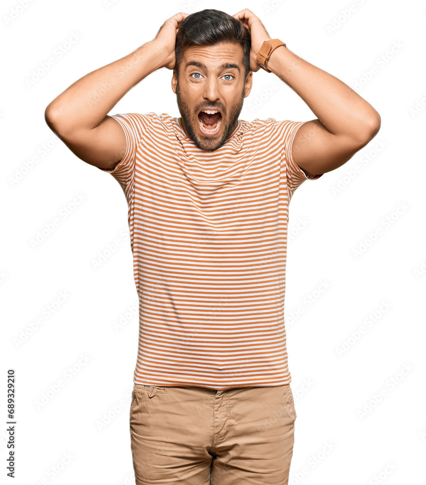 Handsome hispanic man wearing casual clothes crazy and scared with hands on head, afraid and surprised of shock with open mouth Handsome hispanic man wearing casual clothes crazy and scared with hands on head, afraid and surprised of shock with open mouth