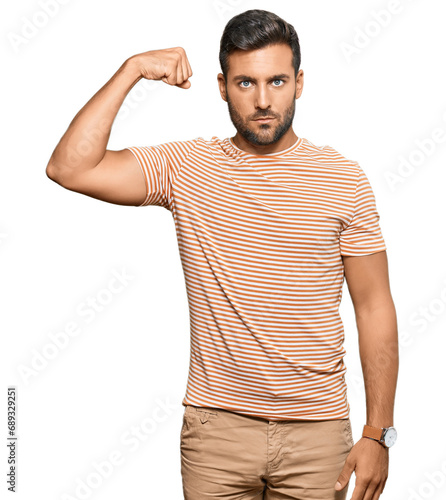 Handsome hispanic man wearing casual clothes strong person showing arm muscle, confident and proud of power