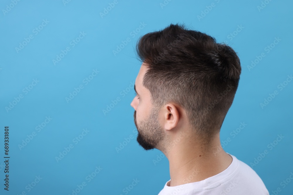 Obraz premium Man with healthy hair on light blue background, space for text