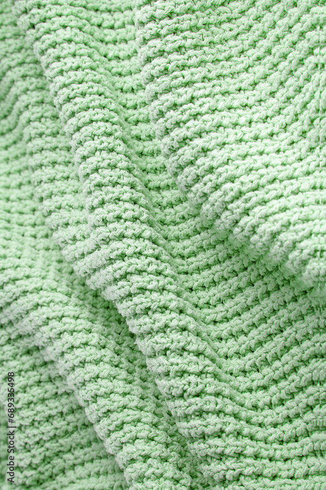 Turquoise green blanket in a large coarse knit with folds. Backdrop for design Turquoise green blanket in a large coarse knit with folds. Backdrop for design