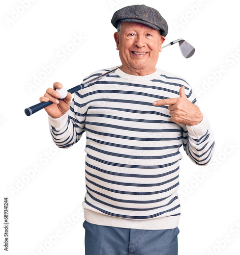 Obraz na płótnie Senior handsome grey-haired man holding golf club and ball pointing finger to one self smiling happy and proud w salonie