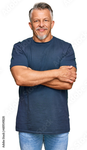 Middle age grey-haired man wearing casual clothes happy face smiling with crossed arms looking at the camera. positive person. © Krakenimages.com