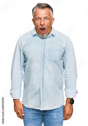 Middle age grey-haired man wearing casual clothes afraid and shocked with surprise and amazed expression, fear and excited face.