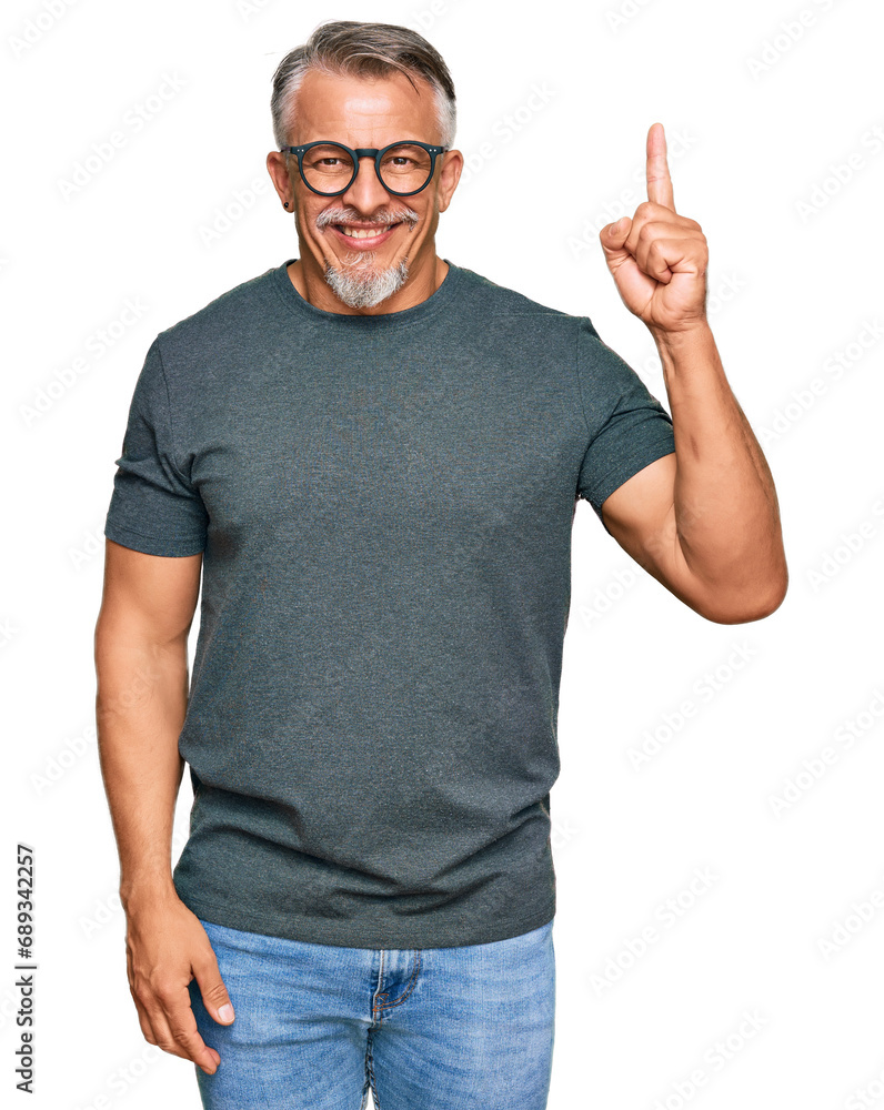Middle age grey-haired man wearing casual clothes and glasses pointing finger up with successful idea. exited and happy. number one. Middle age grey-haired man wearing casual clothes and glasses pointing finger up with successful idea. exited and happy. number one.