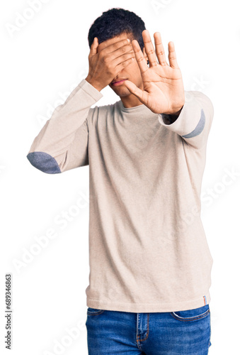 Young african amercian man wearing casual clothes covering eyes with hands and doing stop gesture with sad and fear expression. embarrassed and negative concept.
