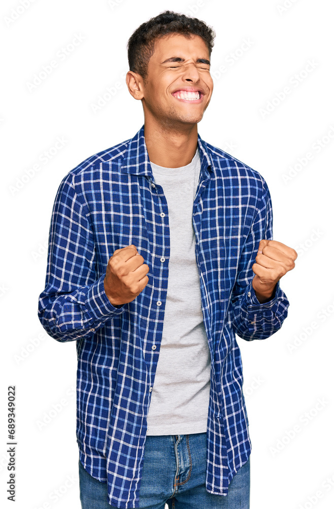 Young handsome african american man wearing casual clothes excited for success with arms raised and eyes closed celebrating victory smiling. winner concept. Young handsome african american man wearing casual clothes excited for success with arms raised and eyes closed celebrating victory smiling. winner concept.
