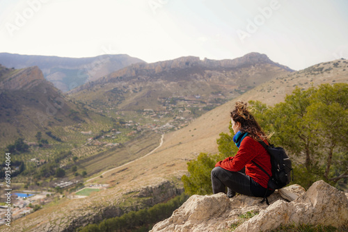 Relaxed mature woman on top of a hill and looking at the city