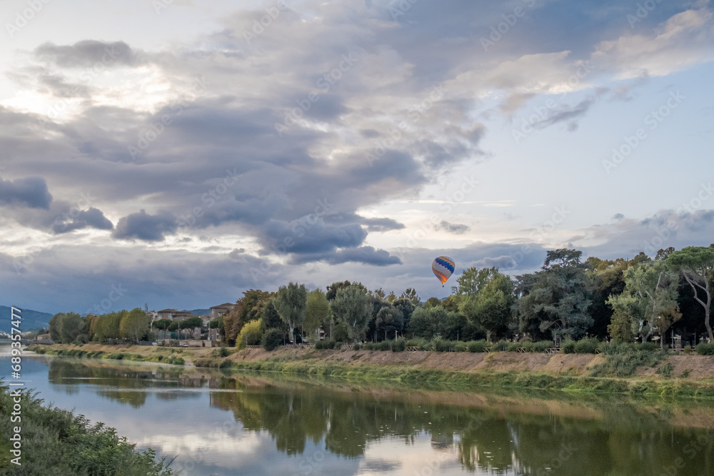 Hot air balloon over Arno river on a cloudy day in Florence, Italy
