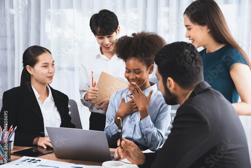 Happy diverse business people work together  discussing in corporate office. Professional and diversity teamwork discuss business plan on desk with laptop. Modern multicultural office worker. Concord