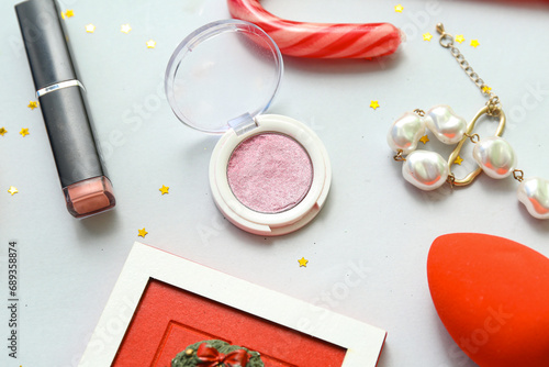 Christmas composition with makeup cosmetics  bracelet and confetti on white background