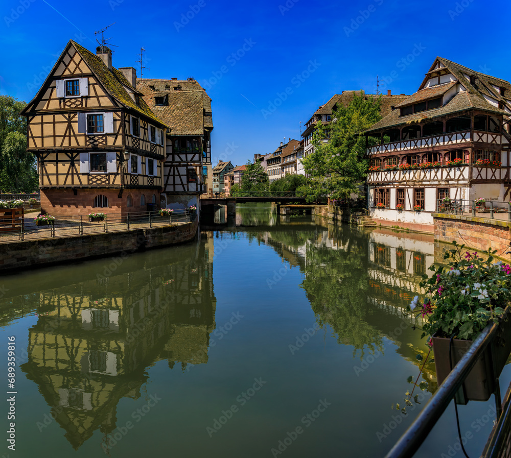 Obraz premium Ornate traditional half timbered houses with blooming flowers along the canals in the picturesque Petite France district of Strasbourg, Alsace, France