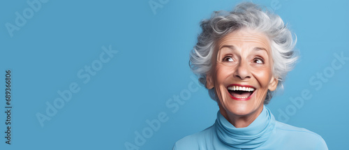 happy grandmother looking to the side with a smile on a blue background - copy space