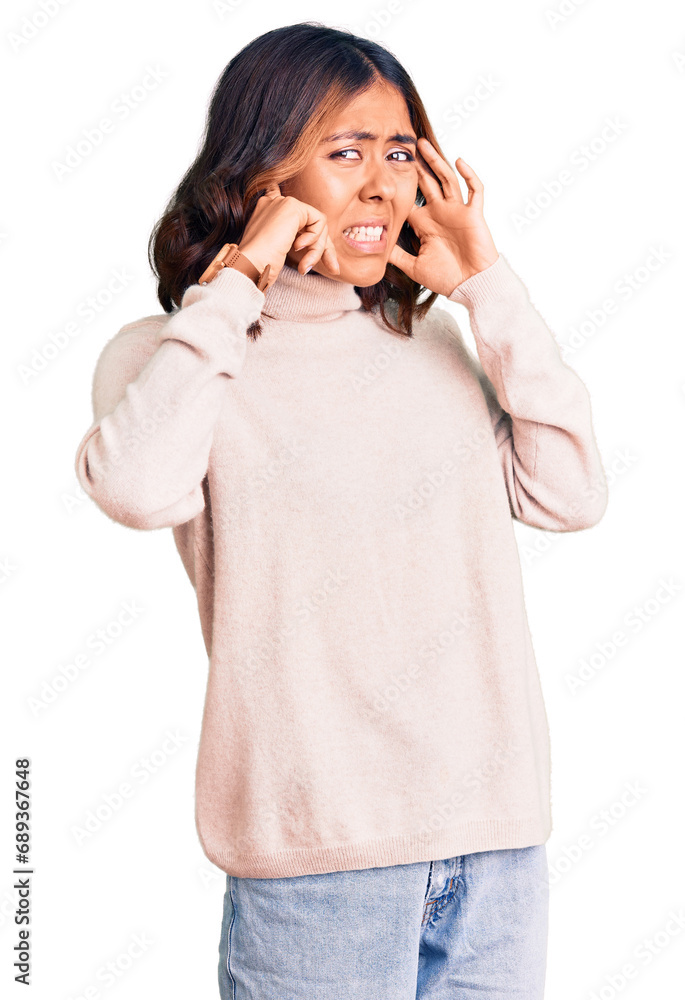 Young beautiful mixed race woman wearing winter turtleneck sweater covering ears with fingers with annoyed expression for the noise of loud music. deaf concept. Young beautiful mixed race woman wearing winter turtleneck sweater covering ears with fingers with annoyed expression for the noise of loud music. deaf concept.