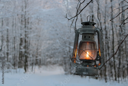 fantasy kerosene lamp shines on a branch in the winter forest © Yar