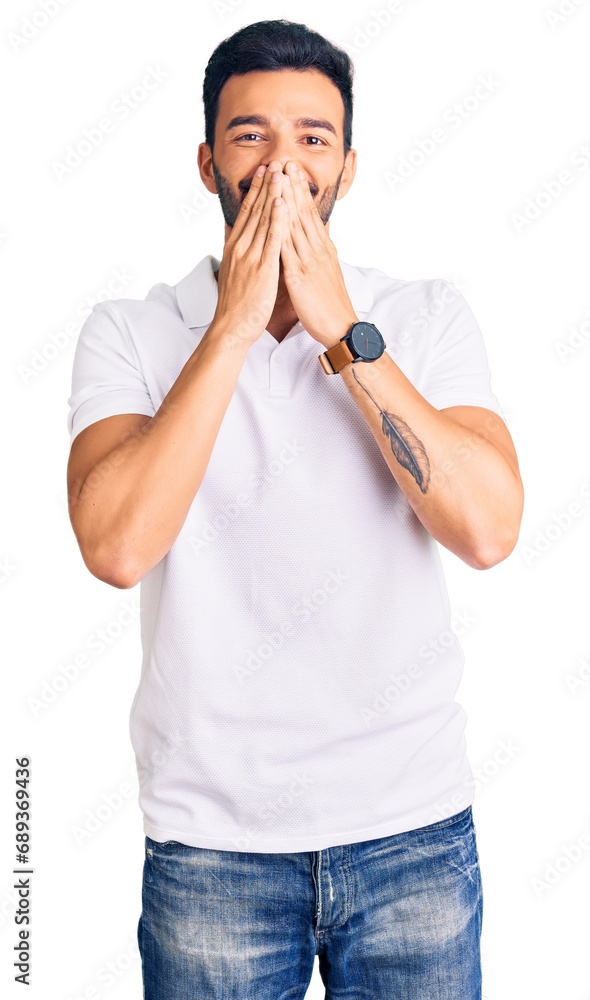 Young handsome hispanic man wearing casual clothes laughing and embarrassed giggle covering mouth with hands, gossip and scandal concept Young handsome hispanic man wearing casual clothes laughing and embarrassed giggle covering mouth with hands, gossip and scandal concept