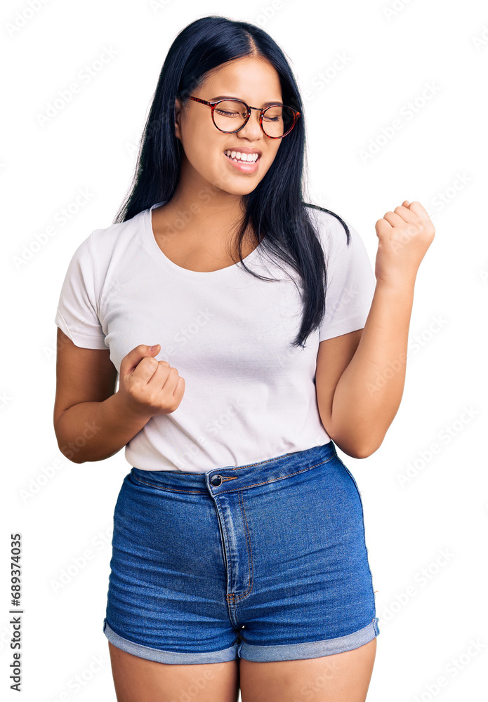 Young beautiful asian girl wearing casual clothes and glasses celebrating surprised and amazed for success with arms raised and eyes closed. winner concept. Young beautiful asian girl wearing casual clothes and glasses celebrating surprised and amazed for success with arms raised and eyes closed. winner concept.