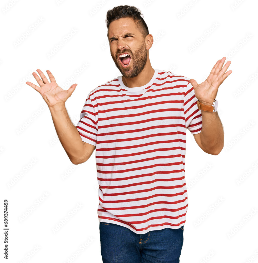Handsome man with beard wearing striped tshirt celebrating mad and crazy for success with arms raised and closed eyes screaming excited. winner concept Handsome man with beard wearing striped tshirt celebrating mad and crazy for success with arms raised and closed eyes screaming excited. winner concept
