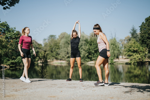 Fit girls stretching and warming up outdoors in a sunny city park. A positive atmosphere for staying fit and enjoying sporty activities with friends.
