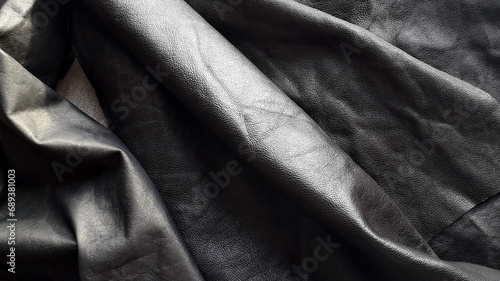 Dark genuine leather for sewing and needlework. Texture of genuine leather. Haberdashery, clothing leather. photo