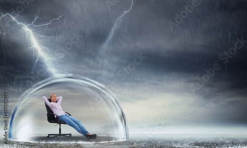 Businesswoman is relaxing during a storm as concept of insurance and protection photo