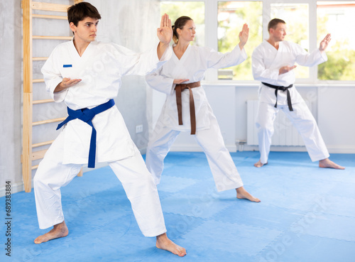 Kata karate teacher conducts classes and performs movements and fighting techniques together with students to prepare them for competitions.