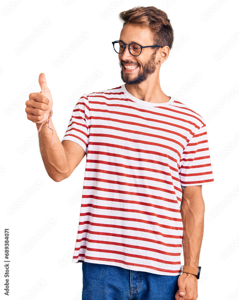 Fototapeta premium Handsome blond man with beard wearing casual clothes and glasses looking proud, smiling doing thumbs up gesture to the side