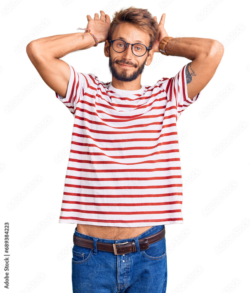 Handsome blond man with beard wearing casual clothes and glasses doing bunny ears gesture with hands palms looking cynical and skeptical. easter rabbit concept. Handsome blond man with beard wearing casual clothes and glasses doing bunny ears gesture with hands palms looking cynical and skeptical. easter rabbit concept.