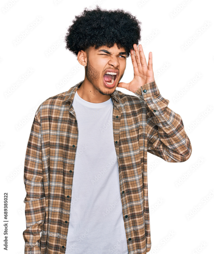 Young african american man with afro hair wearing casual clothes shouting and screaming loud to side with hand on mouth. communication concept. Young african american man with afro hair wearing casual clothes shouting and screaming loud to side with hand on mouth. communication concept.