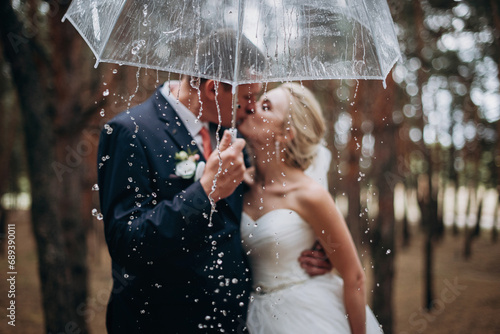 Romantic newlyweds under umbrella. Selective focus