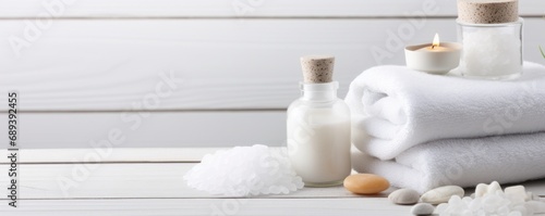 Beauty treatment items for spa procedures on white wooden table. massage stones, essential oils and sea salt. copy space