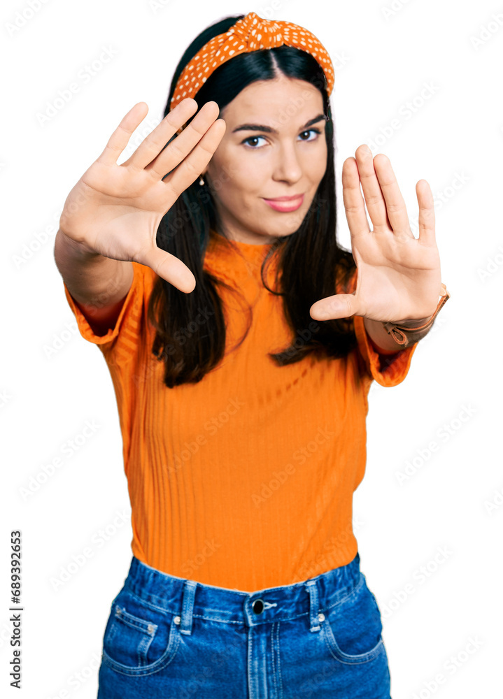 Young hispanic woman wearing casual clothes doing frame using hands palms and fingers, camera perspective Young hispanic woman wearing casual clothes doing frame using hands palms and fingers, camera perspective